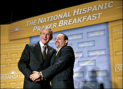 El Presidente George W. Bush es agradecido por el Reverendo Danny Cortés después de dirigirse a los participantes en el Desayuno Nacional Hispano de Oración el jueves, 16 de junio de 2005 en el Andrew Mellon Auditorium en Washington, D.C.