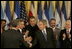 El Presidente George W. Bush estrecha la mano de legisladores, funcionarios del gobierno e invitados el martes, 2 de agosto de 2005 en el East Room de la Casa Blanca después de la ceremonia de promulgación de la CAFTA Implementation Act.