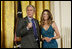 El Presidente George W. Bush junto a la cantante Ana Cristina el viernes, 6 de octubre de 2006, en el East Room de la Casa Blanca, durante la celebración del Mes de la Hispanidad. Foto por Paul Morse de la Casa Blanca