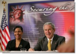 President George W. Bush is joined by Ana Karym, left, of Hyattsville, Md., a volunteer English as a Second Language teacher, during a meeting Thursday, May 3, 2007 on immigration and assimilation at the Asamblea de Iglesias Cristianas, Centro Evangelistico in Washington, D.C. White House photo by Eric Draper