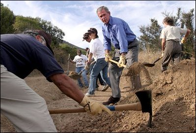 Working alongside volunteers, President George W. Bush lends a hand in repairing the Old Boney Trail at the Santa Monica Mountains National Recreation Area in Thousand Oaks, Calif., Aug. 15, 2003.