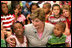 Mrs. Laura Bush embraces two students Monday, Aug. 28, 2006, as she meets and speaks with members of the Gorenflo Elementary School first grade class in their temporary portable classroom at the Beauvoir Elementary School in Biloxi, Miss. The students, whose school was damaged by Hurricane Katrina, are sharing the facilities of the Beauvoir school until their school’s renovations are complete. White House photo by Shealah Craighead 