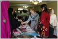 Mrs. Laura Bush greets local businesswomen as she tours the marketplace of the Arzu and Bamiyan Women's Business Association on June 8, 2008 in Afghanistan. The carpets, embroidery and other Afghan wares are all made by women.