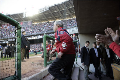 President George W. Bush acknowledges the applause as he exits the dugout Thursday, April 14, 2005, to throw out the first pitch at the Washington Nationals' home opener.  The President's appearance proved good luck as the Nationals defeated the Arizona Diamondbacks, 5-3.