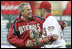 President George W. Bush and Washington Nationals catcher Brian Schneider shake hands after the President threw the ceremonial first pitch Thursday, April 14, 2005.  Schneider went 1 for 3 with an RBI in the Nationals' inaugural home 5-3 win over the Arizona Diamondbacks.