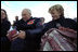 Vice President Dick Cheney signs a football for a Natrona County High School student while watching the school's homecoming game with his high school sweetheart, Lynne Cheney, in Casper, Wyo., Sept. 20, 2002. 