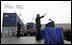 As Homeland Security Secretary Tom Ridge stands nearby, President George W. Bush waves to the audience after delivering remarks on homeland security at the Port of Charleston, S.C., Feb. 5, 2004.