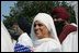 A guest attending the official arrival of India's Prime Minister Dr. Manmohan Singh, holds an American and India flag, Monday, July 18, 2005, on the South Lawn of the White House. 