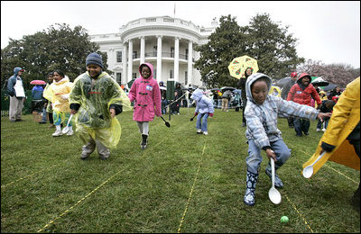 Children slip through a race with their Easter eggs during the traditional race on the South Lawn. Although rainy weather cut short the event, children and their parents made many colorful memories to brighten up a gray, gloomy day.