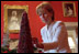 White House Assistant Chief Florist Wendy Elsasser carefully checks each berry of the Red Room Cranberry. Exacting four days of patient care, the tree is a 19-year White House holiday tradition. The practice of decorating the White House rooms with fresh flowers began in the 1850s.