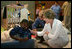 Laura Bush visits with a young boy displaced by Hurricane Katrina in the Cajundome at the University of Louisiana in Lafayette, La., Friday, Sept. 2, 2005.