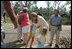 Laura Bush visits with a family outside their hurricane damaged home, Monday, Sept. 5, 2005,  on West Ida Street in Poplarville, Miss. President George W. Bush and Mrs. Bush made the visit during their trip through the hurricane ravaged areas of the Gulf Coast.