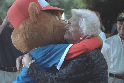 Barbara Bush, the President's mother, hugs the Little League mascot at game's end at the second Tee Ball game on the South Lawn on Sunday, June 3, 2001.