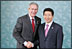 President George W. Bush shakes hands with President Moo Hyun Roh of the Republic of Korea as President Roh welcomes him to the 2005 APEC conference in Busan.