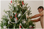 A decorator carefully places ornaments on the official White House Christmas tree Tuesday, Nov. 28, 2006, an 18-foot Douglas fir in the Blue Room of the White House. 