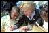 A second grade boy looks on as Mrs. Cheney demonstrates how the founding fathers used quill pens to sign the U.S. Constitution during Constitution Day at the Naval Observatory Sept. 17, 2002. In additions to signing the Constitution, children also learned about 18th century coins and making coin rubbings, created tricorn hats like those worn in the 1700s and played Constitution-era games.