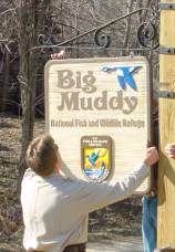 Photo of a Service employee hanging an entrance sign.