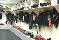 Athletic uniforms hanging in a row over locker room benches