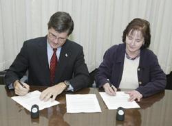 OSHA’s then-Assistant Secretary John Henshaw and Michele Sullivan, Chair, Board of Directors of SCHC, sign the SCHC Alliance on October 22, 2003.