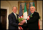 President George W. Bush is presented a bowl of shamrocks by Prime Minister Bertie Ahern of Ireland, during a ceremony Friday, St. Patrick's Day 2006, in the Roosevelt Room of the White House.  White House photo by Kimberlee Hewitt