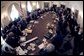 Seen through a fish-eye lens, President George W. Bush talks with reporters during a Cabinet Meeting at the White House Monday, Feb. 2, 2004.  White House photo by Eric Draper
