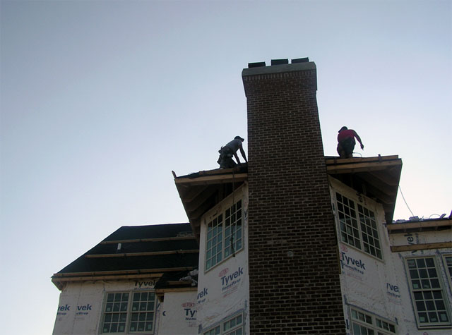 Employees working at approximately 30 feet above grade performing roofing work