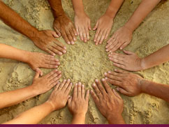 Hands held open in a circle over sand
