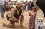 U.S. Marine Corps Major Chris Hughes shares some time with an Iraqi girl during an effort to distribute food and water to Iraqi citizens in need.