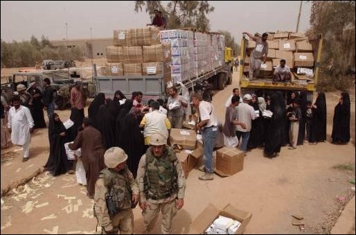 Iraqi volunteers from the city of An Najaf work hand in hand with Kuwaiti volunteers to help to unload water for needy residents during a food and water distribution. The coordinated effort between volunteers citizens from Kuwait and the U.S. Military is helping to provide food and medicine for needy Iraqi people in support of Operation Iraqi Freedom. 