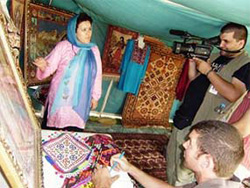 A woman shows off her products in an inaugural agricultural fair in Kunduz, Afghanistan, June 21, 2008. [Sgt. 1st Class Reeba Critser, USNATO ] 