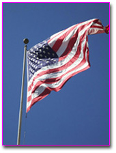 United States flag on a pole blowing in the wind