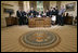 President George W. Bush delivers a Live Radio Address surrounded by Mrs. Bush and families of victims of 911 in the Oval Office, Saturday, Sept. 11, 2004.