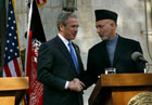 President George W. Bush shakes hands with Afghanistan President Hamid Karzai during a press conference after making a surprise visit to Kabul, Afghanistan, Wednesday, March 1, 2006. [© AP/WWP]