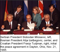 Serbian President Slobodan Milosevic, left, Bosnian President Alija Izetbegovic, center, and Croatian President Franjo Tudjman, right, initial the peace agreement after 21 days of talks in Dayton, Ohio. AP/Wide World photo by David Longstreath