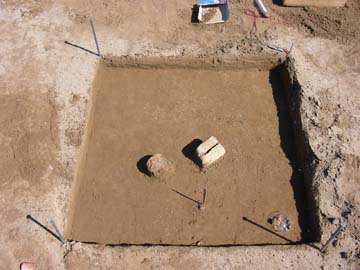 Photo of a worked stone in an archaeological excavation unit