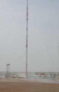 The Independent Radio & Television Network (IRTN) of Diyala as seen from the window of a landing helicopter on March 25, 2007. The smoke in the foreground was to guide the helicopter to the landing zone. At 350 meters, the IRTN has one of the tallest transmission towers in the Middle East.