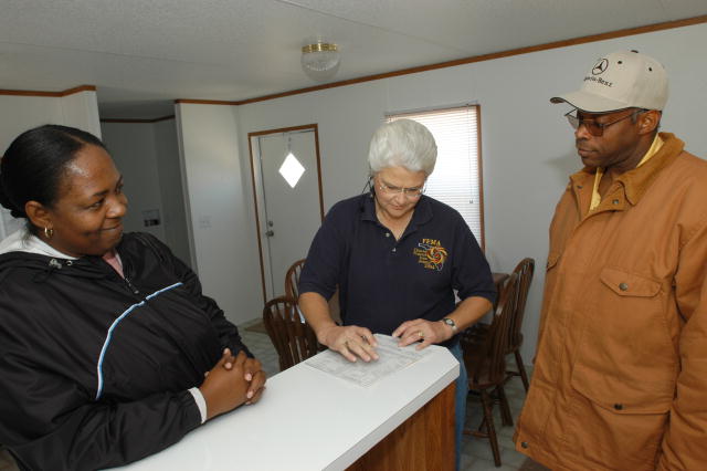 A representative of the Federal Emergency Management Agency goes over paperwork with a couple moving into temporary housing after the hurricanes in Florida.