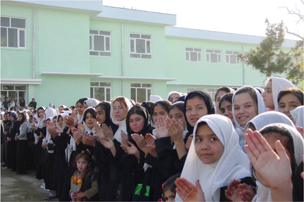 Photo of girls in front of reconstructed school. 