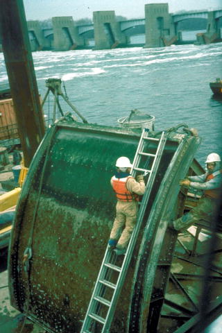 A photo of two workers repairing a Corps navigation project.