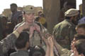 On Nov. 30, 2002, Lt. Col. Wendy Leland of the 4-50th Civil Affairs Battalion distributes school supplies to children in the village of Charikar. Leland and other soldiers from the 4-50th Civil Affair