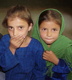 Two sisters, 6-year-old Ferishta (with the green scarf) and Shabham, 7 years old, (left) attending first grade at the Ashaqan Arefan school in Kabul, Afghanistan.  Both girls want to be teachers when they grow up.  