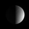 Grooves and deep craters adorn terrain at high southern latitudes on Dione