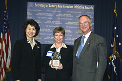 Secretary of Labor Elaine L. Chao (L) and Assistant Secretary of Labor for Disability Employment Policy Roy Grizzard (R) present a 2003 Secretary of Labors New Freedom Initiative Award to Stephanie T. Willey, President-elect, Salisbury Area Chamber of Commerce. (DOL Photo/Shawn Moore)