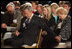 President George W. Bush and Laura Bush holds hands with guests while praying during a ceremony observing the National Day of Prayer in the East Room Thursday, May 5, 2005.