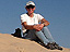 Picture of Diane Evans sitting on top of a sand dune