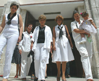Cuban jailed dissidents’ families walk out of the Santa Rita Church, Sunday May 11, 2003 in Havana. For the third Sunday, prisoners’ wives wearing white clothes protest the conditions their husbands a