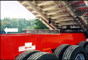 Figure 3. Shows a steel I-beam makeshift body prop: steel I-beam sits across truck frame. The I-beam is not attached to the truck frame or dump body. The I-beam could be displaced in the direction of the arrow by the inadvertent movement of the dump body or truck frame. For problems with accessibility in using figures and illustrations in this document, please contact the Directorate of Science, Technology and Medicine at (202) 693-2300.