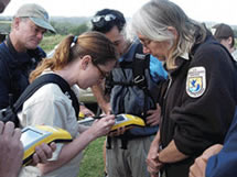 Photo of volunteers learning to use a GPS to map invasive plants.