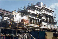 Staging around the super-structure of a ship to provide a work surface for maintenance. Access ladder is shown