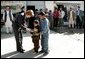 Laura Bush is greeted by youngsters outside a Kabul bakery during her visit Wednesday, March 30, 2005. The first lady presented White House red, white & blue kaleidoscopes to the children. White House photo by Susan Sterner